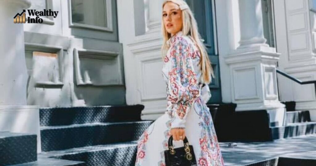 Amanda Ivanelli walking outdoors in a patterned dress — Amanda Ivanelli net worth.