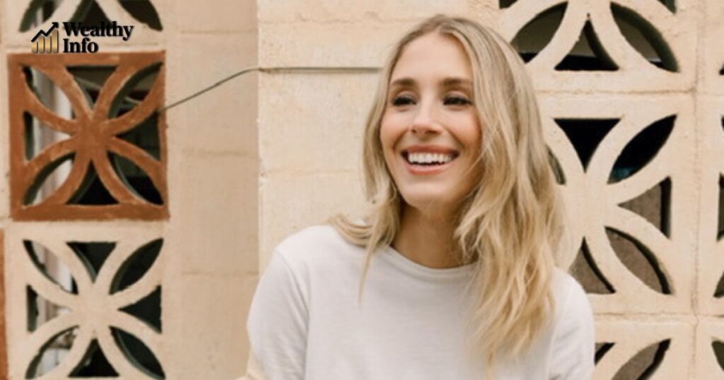 Lisa Gilroy smiling outdoors in a white outfit, reflecting her cheerful personality and growing success that adds to her rising net worth in 2025.